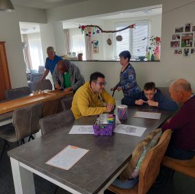 Bewoners samen aan tafel in de gezamenlijke woonkamer van Domus Pastorale