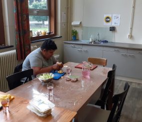 Deelnemer geniet van een zelfgemaakte maaltijd bij de Keuken van Gulick